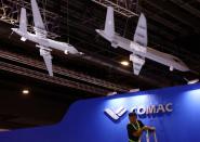 A worker fixes cables at the Comac booth ahead of the Singapore Airshow at Changi Exhibition Centre in Singapore