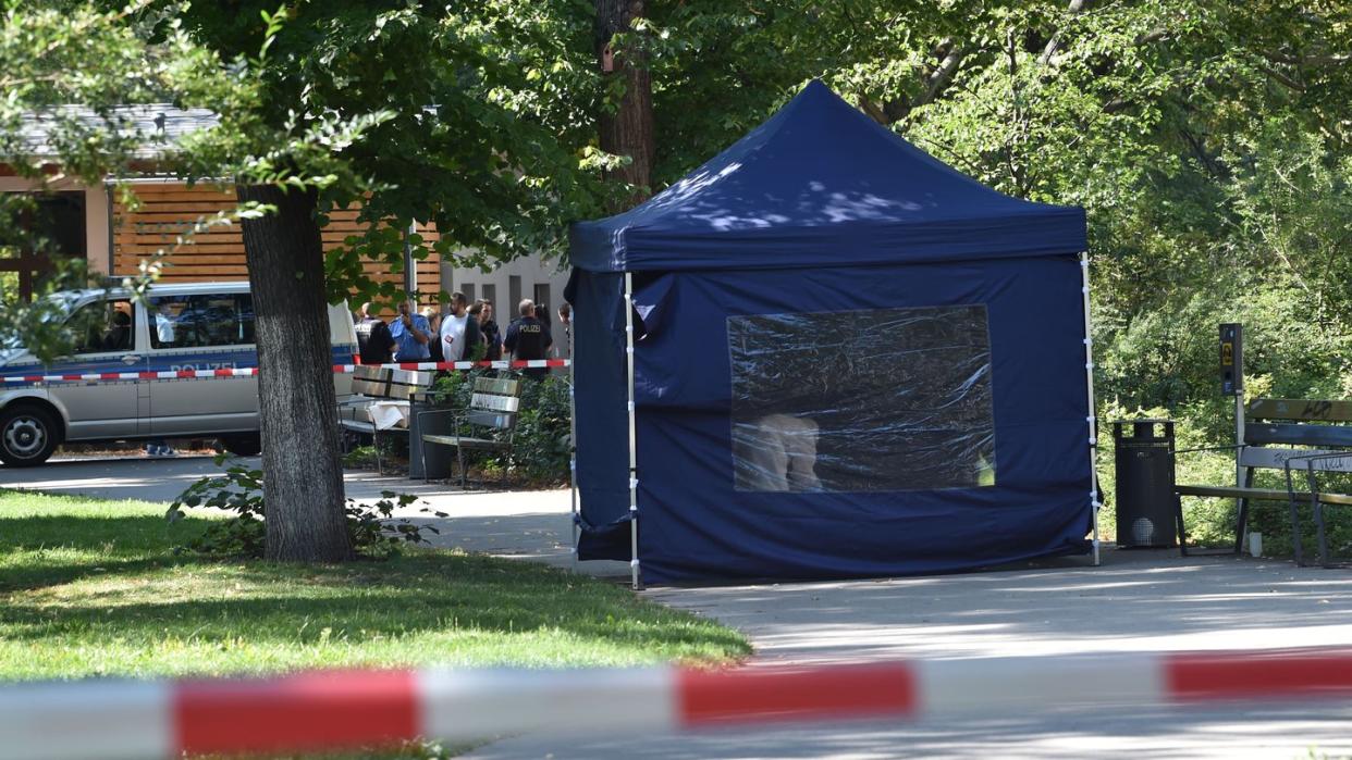 Polizisten sichern in einem Faltpavillon Spuren am Tatort. Foto: Paul Zinken