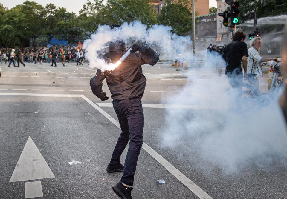 A demonstrator throws a firework against police units during an demonstration against the G-20 Summit on July 7, 2017 in Hamburg, Germany.