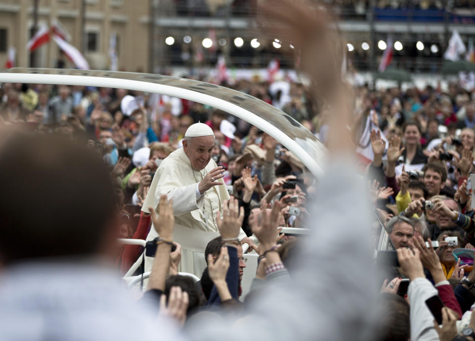 Pope Francis is driven through the crowd in St. Peter's Square at the Vatican, Sunday, April 27, 2014. Pope Francis has declared his two predecessors John XXIII and John Paul II saints in an unprecedented canonization ceremony made even more historic by the presence of retired Pope Benedict XVI. (AP Photo/Vadim Ghirda)