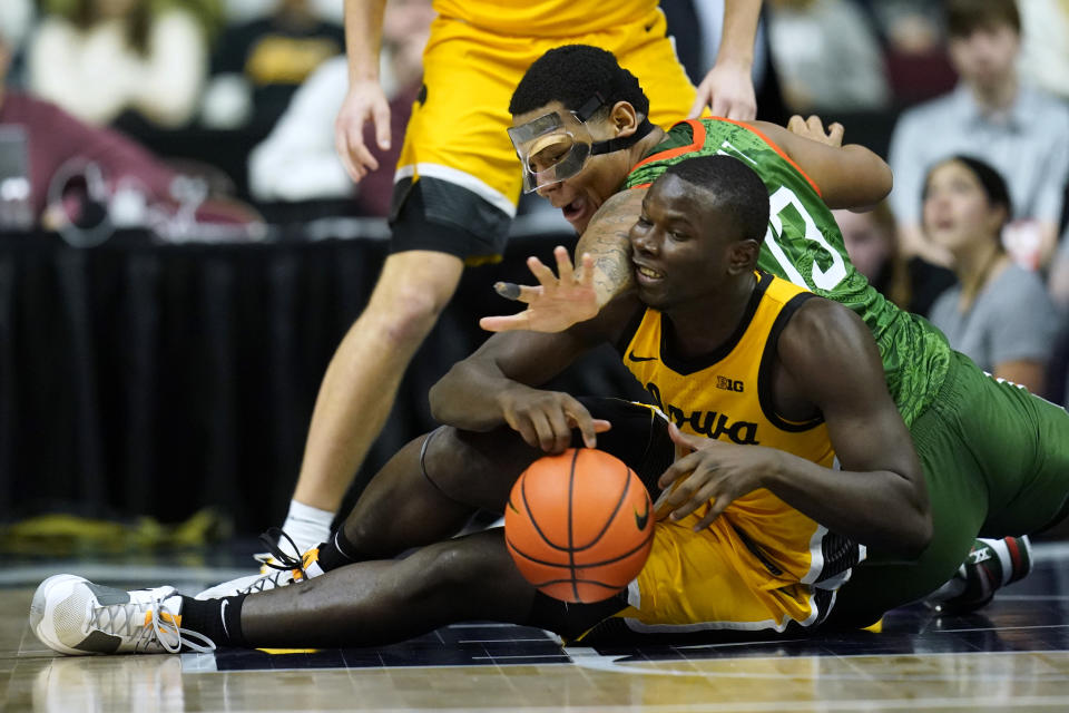 Iowa forward Ladji Dembele fights for a loose ball with Florida A&M forward Shannon Grant, rear, during the second half of an NCAA college basketball game, Saturday, Dec. 16, 2023, in Des Moines, Iowa. (AP Photo/Charlie Neibergall)