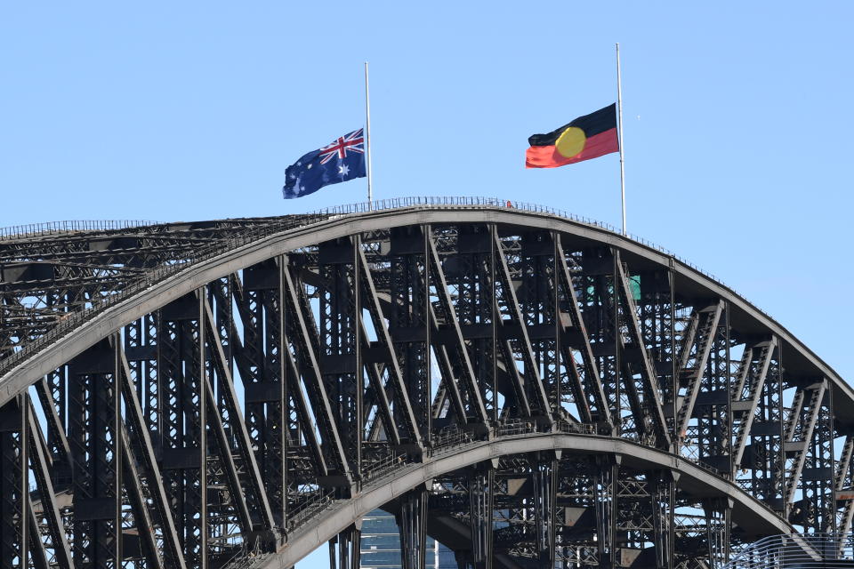 The Australian national flag and the Aboriginal flag are seen at half mast atop the Sydney Harbour Bridge as a sign of respect for the passing of Queen Elizabeth II on September 17, 2022 in Sydney, Australia