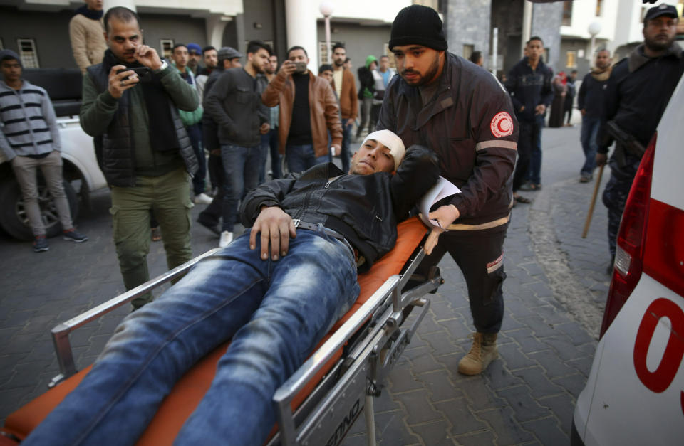 Palestinian medics a wounded youth, who was shot by Israeli troops during a protest at the Gaza Strip's border with Israel, into the treatment room of Shifa hospital in Gaza City, Friday, Jan. 11, 2019. (AP Photo/Adel Hana)