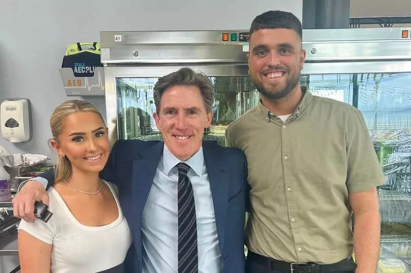 Rob Brydon poses for a picture after enjoying lunch at Verdi's in Mumbles, Swansea, with staff members Amy Lloyd and Calvin Palla -Credit:Verdi's