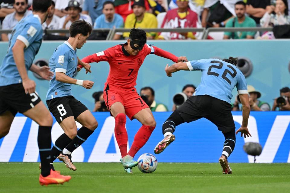 Son Heung-min fights for the ball with Uruguay's defender Martin Caceres (AFP via Getty Images)