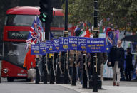 Anti Brexit protestors show their posters in front of parliament in London, Wednesday, Oct. 23, 2019. Britain's government is waiting for the EU's response to its request for an extension to the Brexit deadline. (AP Photo/Frank Augstein)