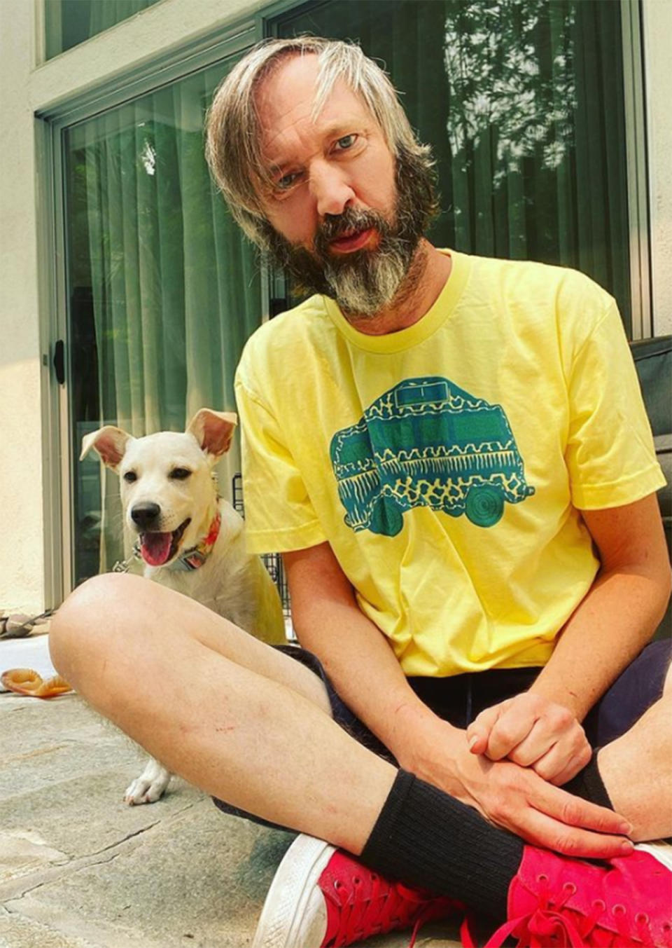 Tom Green wearing a yellow t-shirt with his dog. Photo: Instagram/tomgreen.