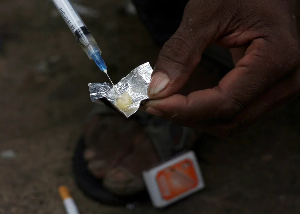 Una jeringa aspira una mezcla de heroína y agua preparada en un envoltorio de aluminio mientras los adictos se inyectan en Stone Town Zanzíbar, 22 de diciembre de 2009. REUTERS/Katrina Manson/File Photo