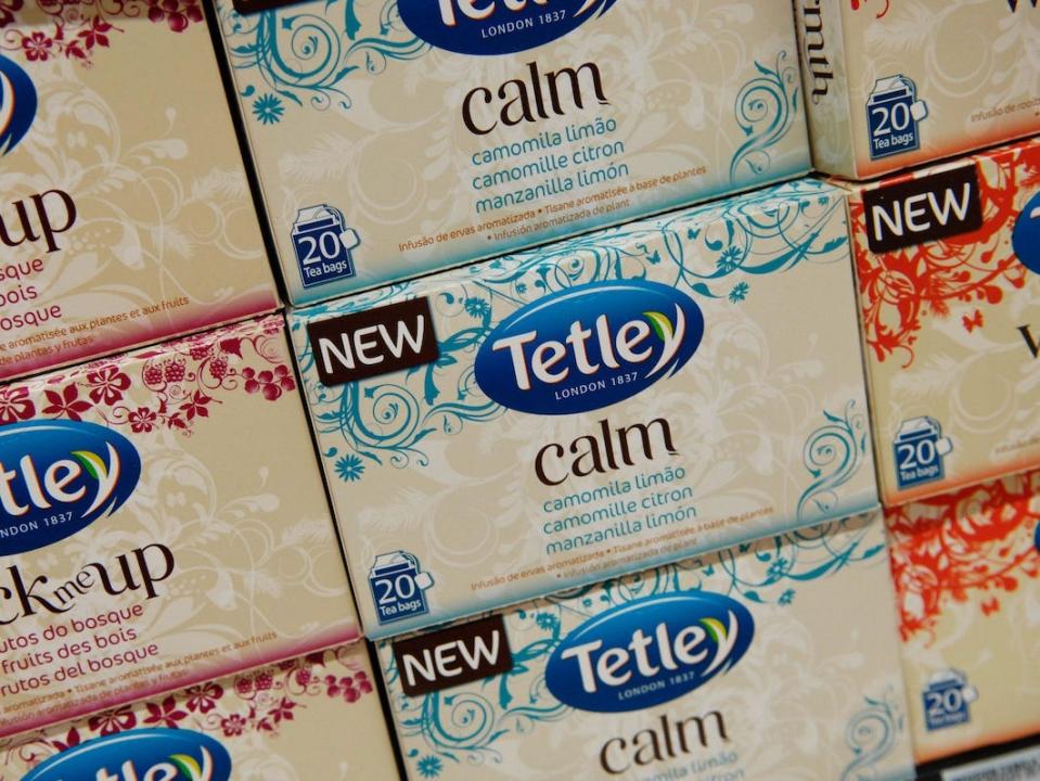 A close-up image that shows boxes of Tetley tea stacked on a shelf at a supermarket.