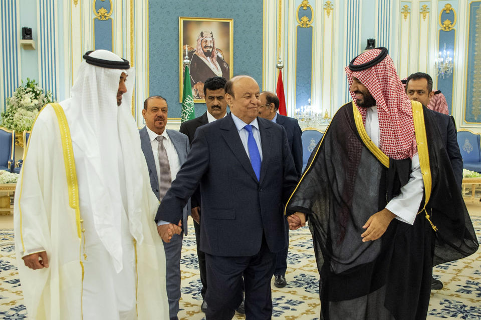 In this photo released by the Saudi Royal Palace, Yemen's president, Abed Rabbo Mansour Hadi, center, is accompanied by Saudi Arabia's Crown Prince Mohammed bin Salman, right, and Dhabi's crown prince, Mohammed bin Zayed Al Nahyan before signing a power-sharing deal in Riyadh, Saudi Arabia, Tuesday, Nov. 5, 2019. Yemen's internationally recognized government has signed a power-sharing deal with Yemeni separatists that are backed by the United Arab Emirates. The deal aims to halt months of infighting between the two groups. (Bandar Aljaloud/Saudi Royal Palace via AP)