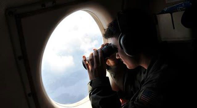 U.S. Navy LT. JG Dylon Porlas uses binoculars to look through the window of a U.S. Navy Lockheed P-3C Orion patrol aircraft from Sicily on Sunday, searching <p>the area in the Mediterranean Sea for the Egyptair flight 804. Photo: AP Photo/Salvatore Cavalli