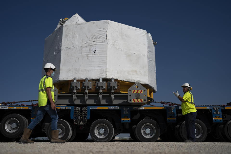 Workers secure a central solenoid magnet for the ITER project as it departs from Berre-l'Etang in southern France, Monday, Sept. 6, 2021. The first part of a massive magnet so strong its American manufacturer claims it can lift an aircraft carrier arrived Thursday, Sept. 9, 2021 at a high-security site in southern France, where scientists hope it will help them build a 'sun on earth.' Almost 60-feet tall and 14 feet in diameter when fully assembled, the magnet is a crucial component of the International Thermonuclear Experimental Reactor, or ITER, a 35-nation effort to develop an abundant and safe source of nuclear energy for future generations.(AP Photo/Daniel Cole)