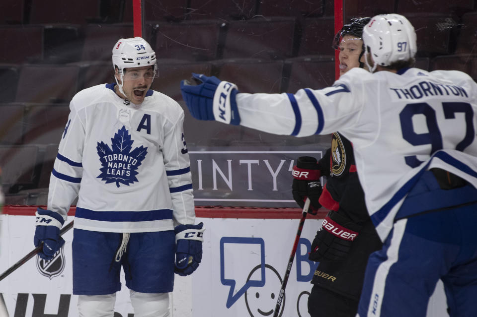 Toronto Maple Leafs center Joe Thornton races to congratulate teammate Auston Matthews on his goal as Ottawa Senators left wing Brady Tkachuk looks on during the first period of an NHL hockey game in Ottawa, Ontario, Saturday, Jan. 16, 2021. (Adrian Wyld/The Canadian Press via AP)