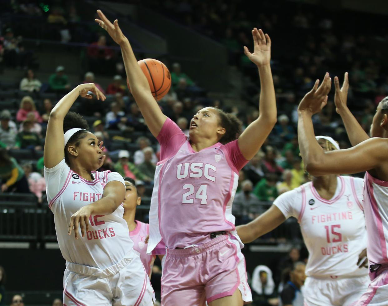 Oregon’s Kennedi Williams, left, passes the ball behind USC’s Kaitlyn Davis during the second half at Matthew Knight Arena in Eugene Friday, Feb. 16, 2024.