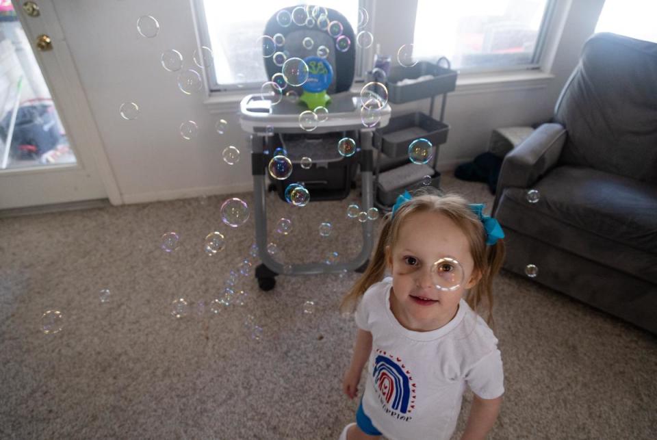 Amelia Whites, 3, plays with bubbles at her home in New Braunfels, on July 27, 2023. Whites, who has heart and neurological issues and uses a gastrostomy tube to eat, is one of thousands of Texas children who lost coverage under Medicaid in the recent months.