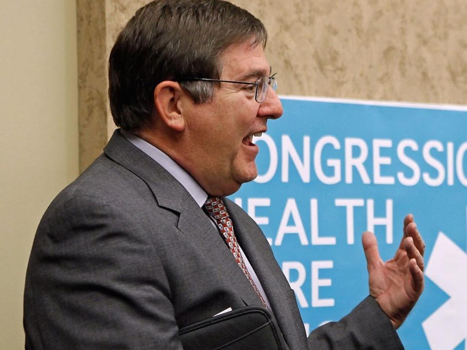 Rep. Michael Burgess, a Republican of Texas, smiles and gestures while greeting America's Health Insurance Plans President and CEO Karen Ignagni during a policy meeting on Capitol Hill.