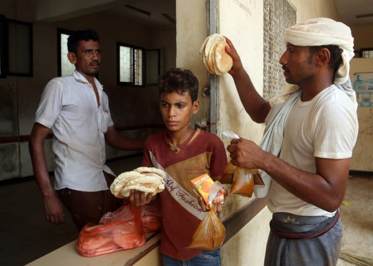 Displaced Yemenis receive food at a school in the city of Hodeida after being evacuated from a village near the airport