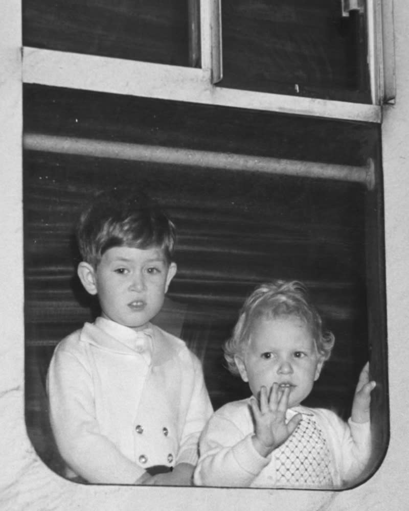 King Charles and Princess Anne look out of the window