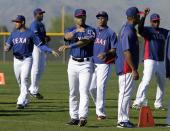 Seattle Seahawks quarterback Russell Wilson, center, runs through morning stretches with the Texas Rangers during spring training baseball practice, Monday, March 3, 2014, in Surprise, Ariz. (AP Photo/Tony Gutierrez)