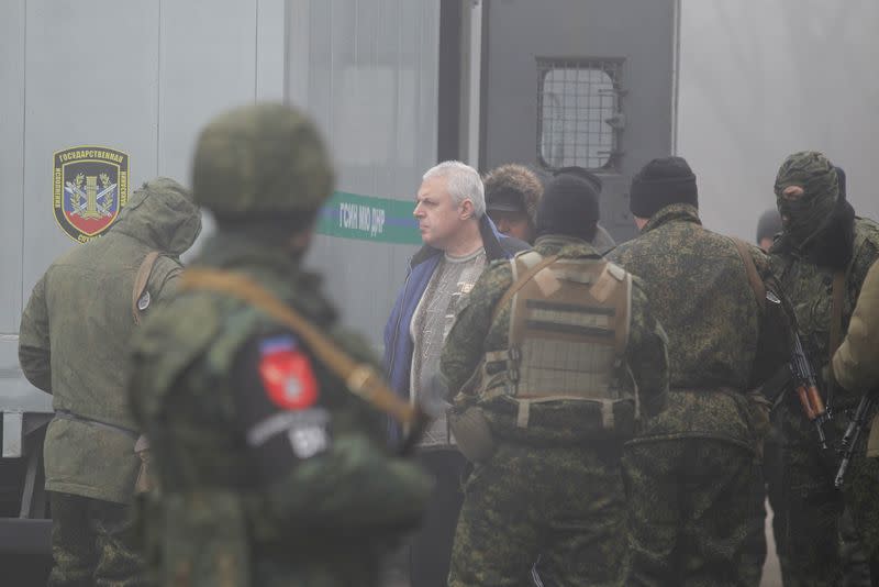 Men are escorted during prisoner of war exchange between Ukraine and the separatist republics in Donetsk region