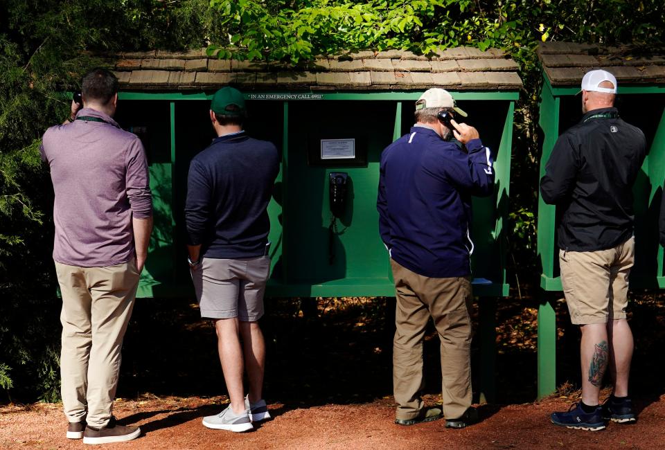 FILE - Apr 8, 2022; Augusta, Georgia, USA; Patrons make a call from the course using one of the phone banks located at different locations around the course during the second round of The Masters golf tournament at Augusta National Golf Course. Mandatory Credit: Katie Goodale-Augusta Chronicle/USA TODAY Sports