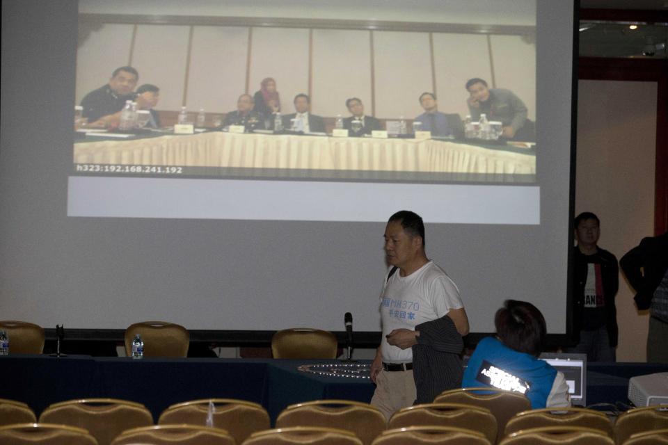 Wen Wanchang, whose son was on board the missing Malaysia Airlines 370, walks out to protest the difficulties of communicating with Malaysian officials through video conferencing in Beijing, China, Wednesday, April 16, 2014. A robotic submarine looking for the lost Malaysian jet continued its second seabed search on Wednesday as up to 14 planes were to take to the skies for some of the final sweeps of the Indian Ocean for floating debris from the ill-fated airliner. (AP Photo/Ng Han Guan)