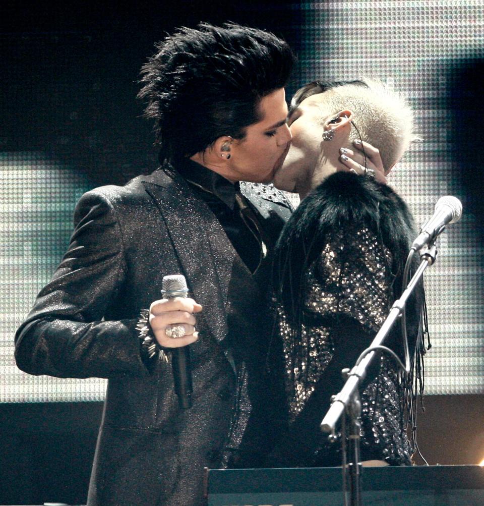 Adam Lambert, left, kisses one of the dancers as he performs during the closing act of the 37th Annual American Music Awards on Sunday, Nov. 22, 2009, in Los Angeles. (AP Photo/Matt Sayles) ORG XMIT: CADC229