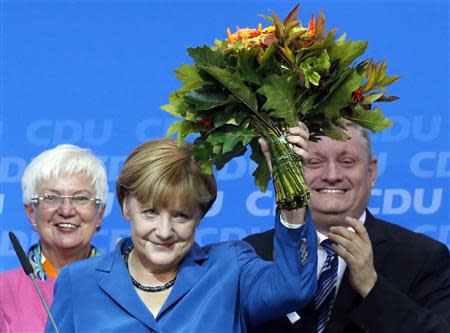 German Chancellor and leader of Christian Democratic Union (CDU) Angela Merkel is applauded by Gerda Hasselfeldt, head of the faction of Christian Social Union (CSU) in Berlin (L) and CDU party secretary general Hermann Groehe after first exit polls in the German general election (Bundestagswahl) at the CDU party headquarters in Berlin September 22, 2013. REUTERS/Fabrizio Bensch