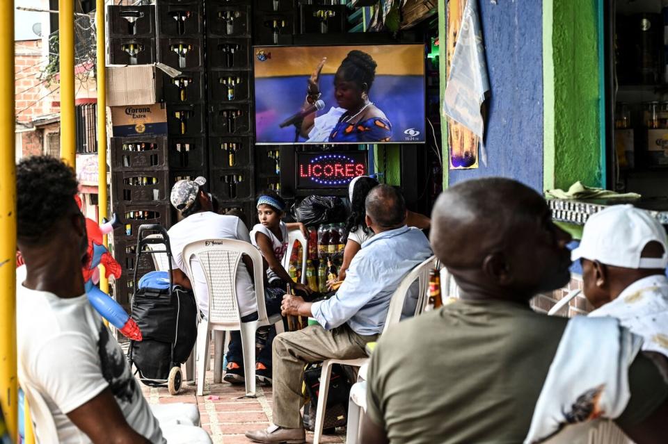 A group of people watches TV