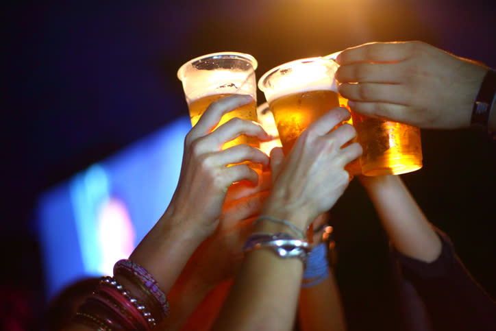 A file photo of a group of people holding up cups of beer. Dozens of people at a Schofields party in Sydney are expected to be fined for breaching coronavirus restrictions.