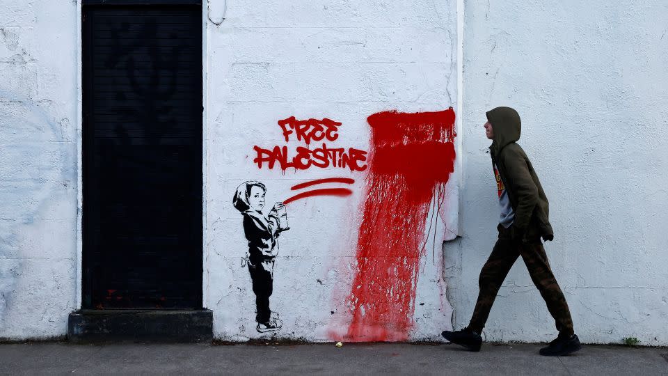 A man walks past graffiti reading 'Free Palestine', amid the ongoing conflict between Israel and the Palestinian Islamist group Hamas, in Dublin, Ireland, November 15. - Clodagh Kilcoyne/Reuters