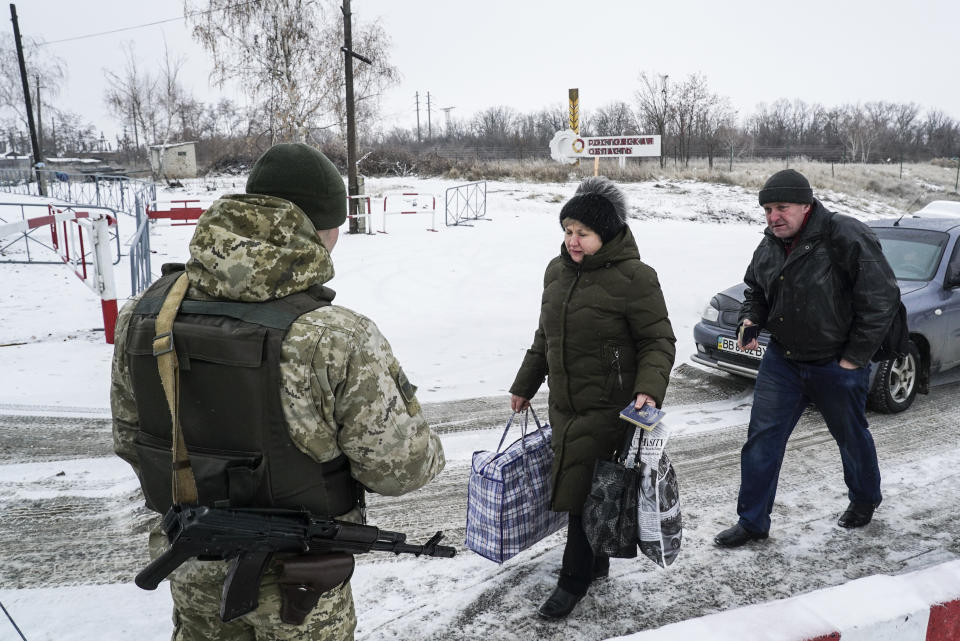 Ukrainians cross the border from Russia to Ukrainian side of the Ukraine - Russia border in Milove town, eastern Ukraine, Sunday, Dec. 2, 2018. On a map, Chertkovo and Milove are one village, crossed by Friendship of Peoples Street which got its name under the Soviet Union and on the streets in both places, people speak a mix of Russian and Ukrainian without turning choice of language into a political statement. (AP Photo/Evgeniy Maloletka)
