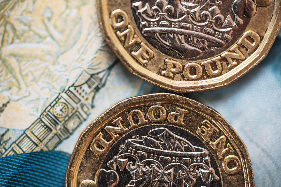 Detail of a One Pound (GBP) coin. The Big Ben design in the background comes from a 5 GBP banknote.