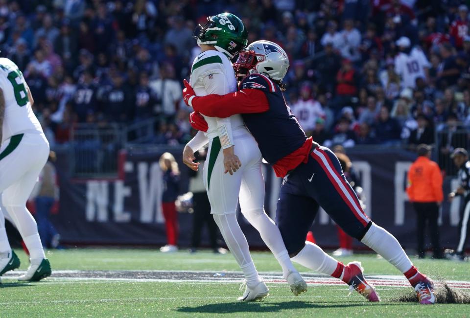 New York Jets quarterback Zach Wilson (2) gets hit by New England Patriots outside linebacker Matt Judon (9) in the second quarter.