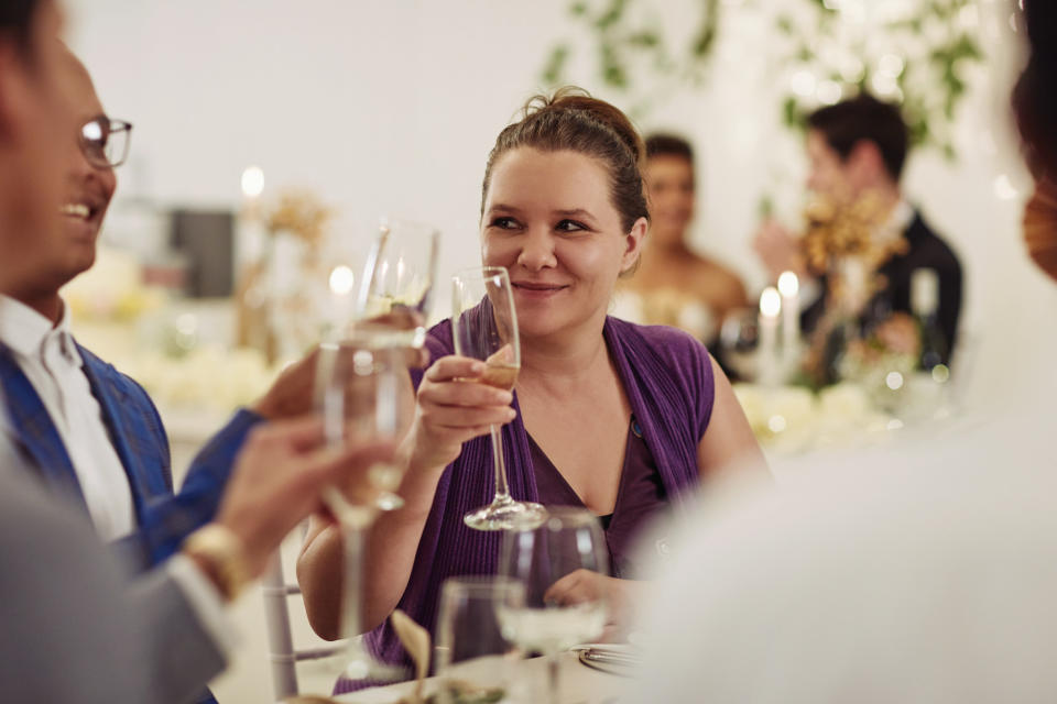 People clinking glasses around a table