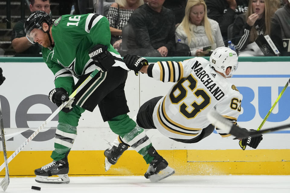 Boston Bruins left wing Brad Marchand (63) loses his footing while competing for the puck with Dallas Stars center Joe Pavelski during the first period of an NHL hockey game, Monday, Nov. 6, 2023, in Dallas. (AP Photo/Julio Cortez)