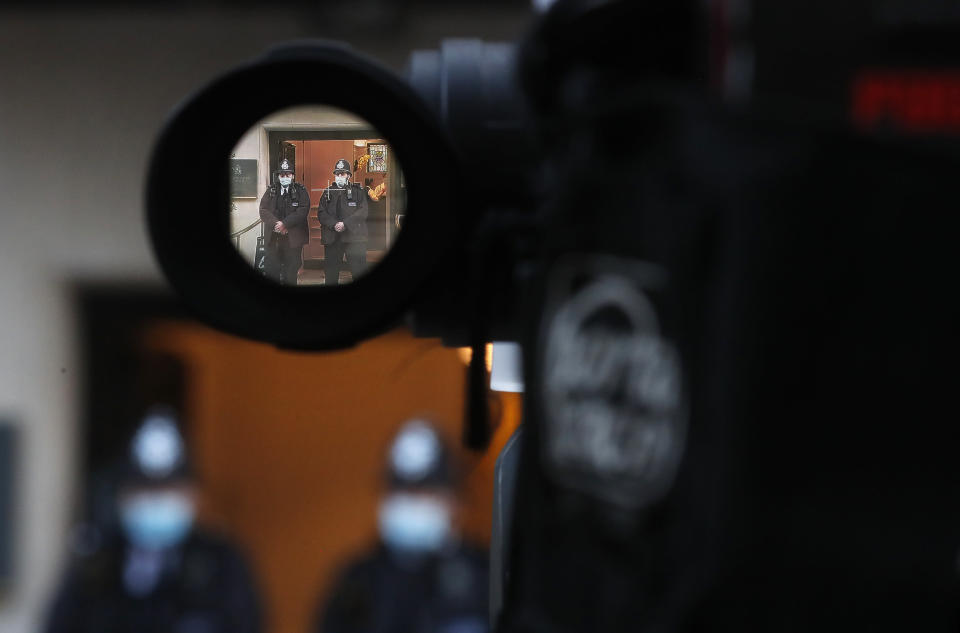 Police officers are seen through a camera view finder as they stand outside King Edward VII's hospital in London, Thursday, Feb. 18, 2021. Buckingham Palace says 99-year-old Prince Philip has been admitted to a London hospital after feeling unwell. The palace said the husband of Queen Elizabeth II was admitted to the private King Edward VII Hospital on Tuesday evening. (AP Photo/Frank Augstein)