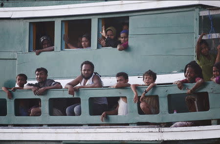 Migrants are seen aboard a boat tethered to a Thai navy vessel, in waters near Koh Lipe island, May 16, 2015. REUTERS/Olivia Harris