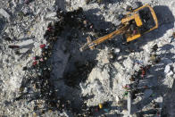 Rescuers and residents search through the rubble of collapsed buildings in the town of Harem near the Turkish border, Idlib province, Syria, Wednesday, Feb. 8, 2023. With the hope of finding survivors fading, stretched rescue teams in Turkey and Syria searched Wednesday for signs of life in the rubble of thousands of buildings toppled by a catastrophic earthquake. (AP Photo/Ghaith Alsayed)