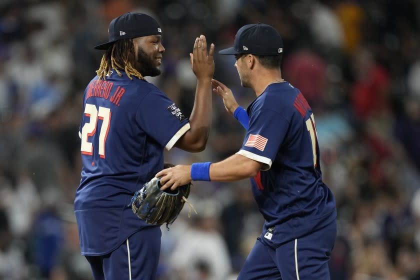 American League's Vladimir Guerrero Jr., of the Toronto Blue Jays, greets Whit Merrifield, of the Kansas City Royals, right, after the MLB All-Star baseball game, Tuesday, July 13, 2021, in Denver. The American League defeated the National League 5-2. (AP Photo/David Zalubowski)