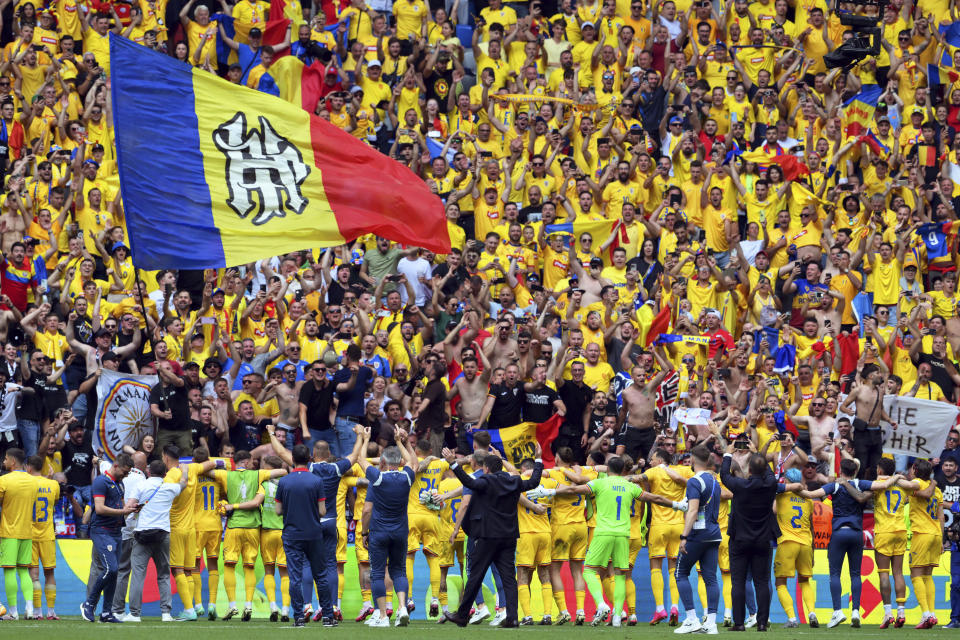 Romania team members celebrate in front of their fans after winning the Group E match between Romania and Ukraine at the Euro 2024 soccer tournament in Munich, Germany, Monday, June 17, 2024. (Peter Kneffel/dpa via AP)