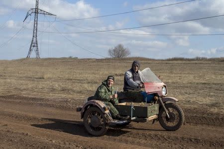 Pro-Russian rebels ride on a motorcycle on a front line outside the village of Molochnoye, north-east from Donetsk, March 8, 2015. REUTERS/Marko Djurica