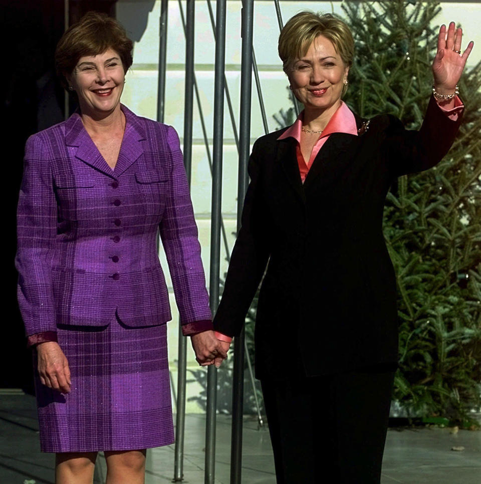FILE - First lady Hillary Clinton waves to the media as she greets incoming first lady Laura Bush upon her arrival to the White House, where they will have tea Dec. 18, 2000. (AP Photo/Doug Mills, File)