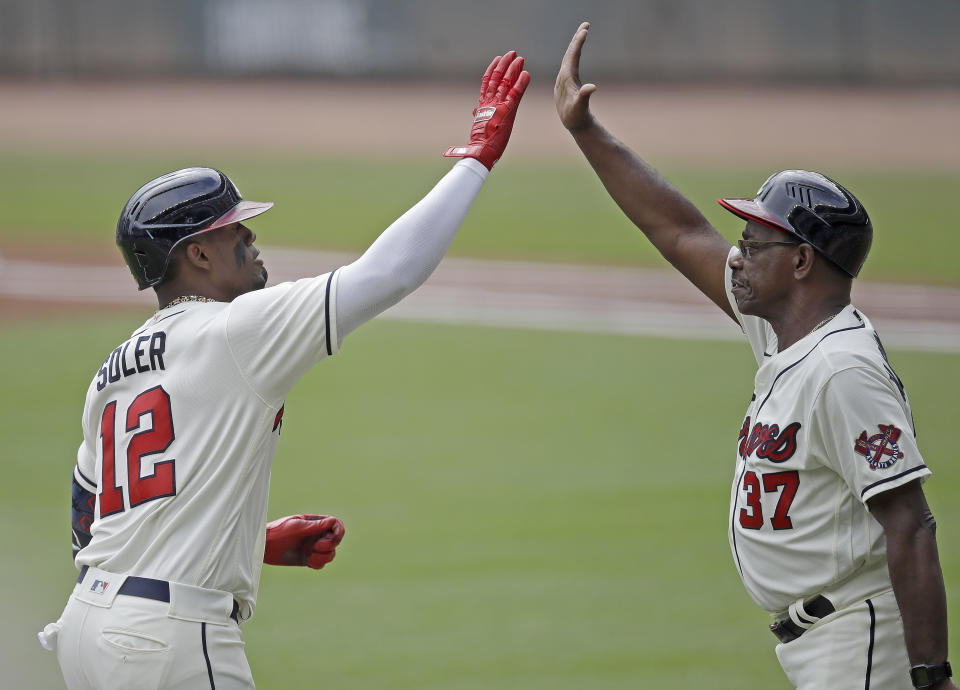 Atlanta Braves' Jorge Soler (12) is congratulated by third base coach Ron Washington, right, after hitting a home run off New York Mets pitcher Noah Syndergaard in the first inning of a baseball game Sunday, Oct. 3, 2021, in Atlanta. (AP Photo/Ben Margot)