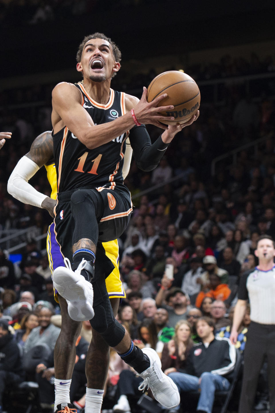 Atlanta Hawks guard Trae Young drives and scores during the second half of an NBA basketball game against the Los Angeles Lakers, Friday, Dec. 30, 2022, in Atlanta. (AP Photo/Hakim Wright Sr.)