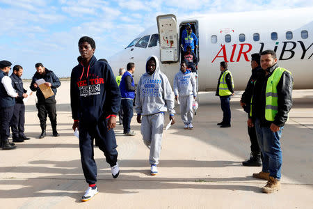 Guinean migrants, transported from Zewara, exit a plane before they are deported to Guinea, in Misrata, Libya, December 27, 2017. REUTERS/Ismail Zitouny