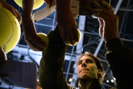 Rafael Nadal of Spain signs autographs after defeating Roger Federer of Switzerland in their men's singles semi-final tennis match at the ATP World Tour Finals at the O2 Arena in London November 10, 2013. REUTERS/Dylan Martinez