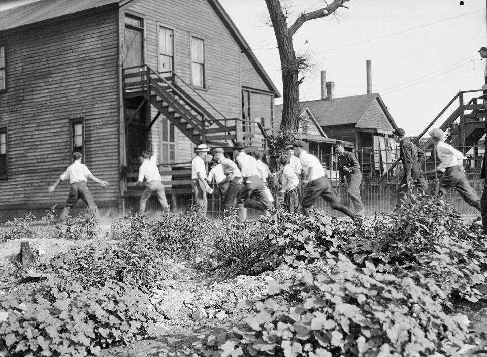 In this 1919 photo provided by the Chicago History Museum, a victim is stoned and bludgeoned under a corner of a house during the race riots in Chicago. Hundreds of African Americans died at the hands of white mobs during “Red Summer,” as the summer of 1919 came to be known, but little is known nationally about this summer of violence 100 years later. (Chicago History Museum/The Jun Fujita negatives collection via AP)