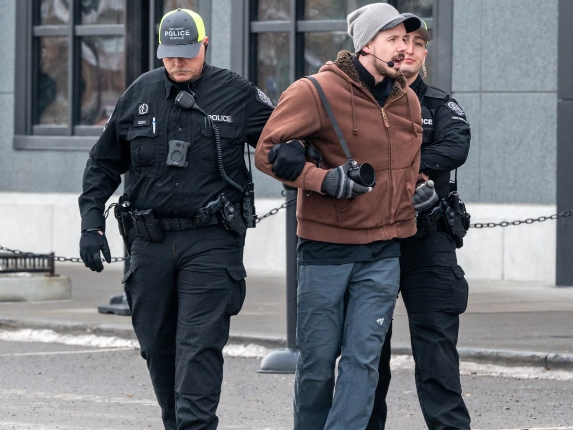 Derek Reimer is escorted away from an all-ages drag brunch at the Rec Room in January. He was later arrested and charged with hate-motivated crimes after disrupting a storytime event at the Seton public Library on Feb. 25. (Brangwyn Jones - image credit)