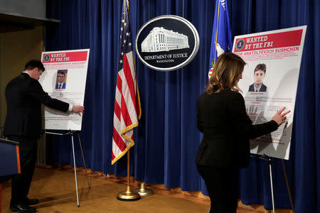 Department of Justice staffers install posters of a suspected Russian hacker before FBI National Security Division and the U.S. Attorney's Office for the Northern District of California joint news conference at the Justice Department in Washington, U.S., March 15, 2017. REUTERS/Yuri Gripas